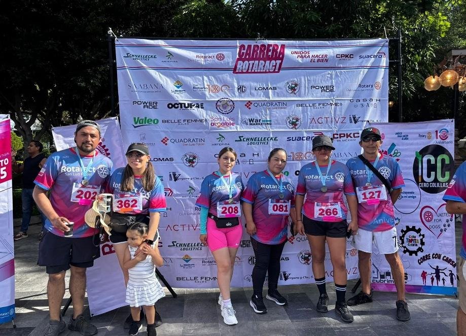 Corredores con números y medallas frente al backdrop
